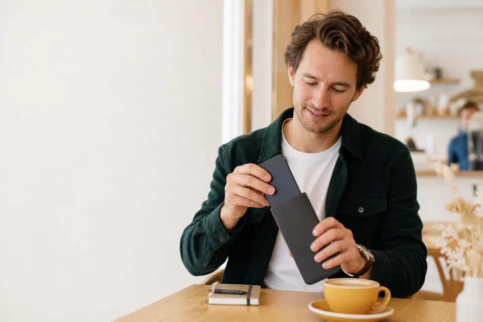 Un homme range son smartphone dans une protection